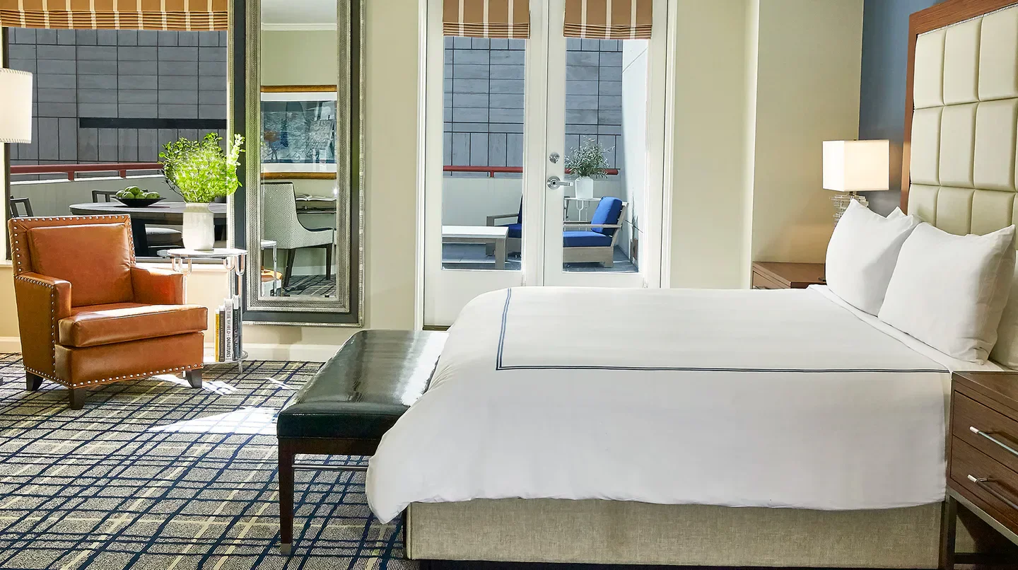 Cozy bedroom at The Adolphus, Autograph Collection in Dallas with balcony access