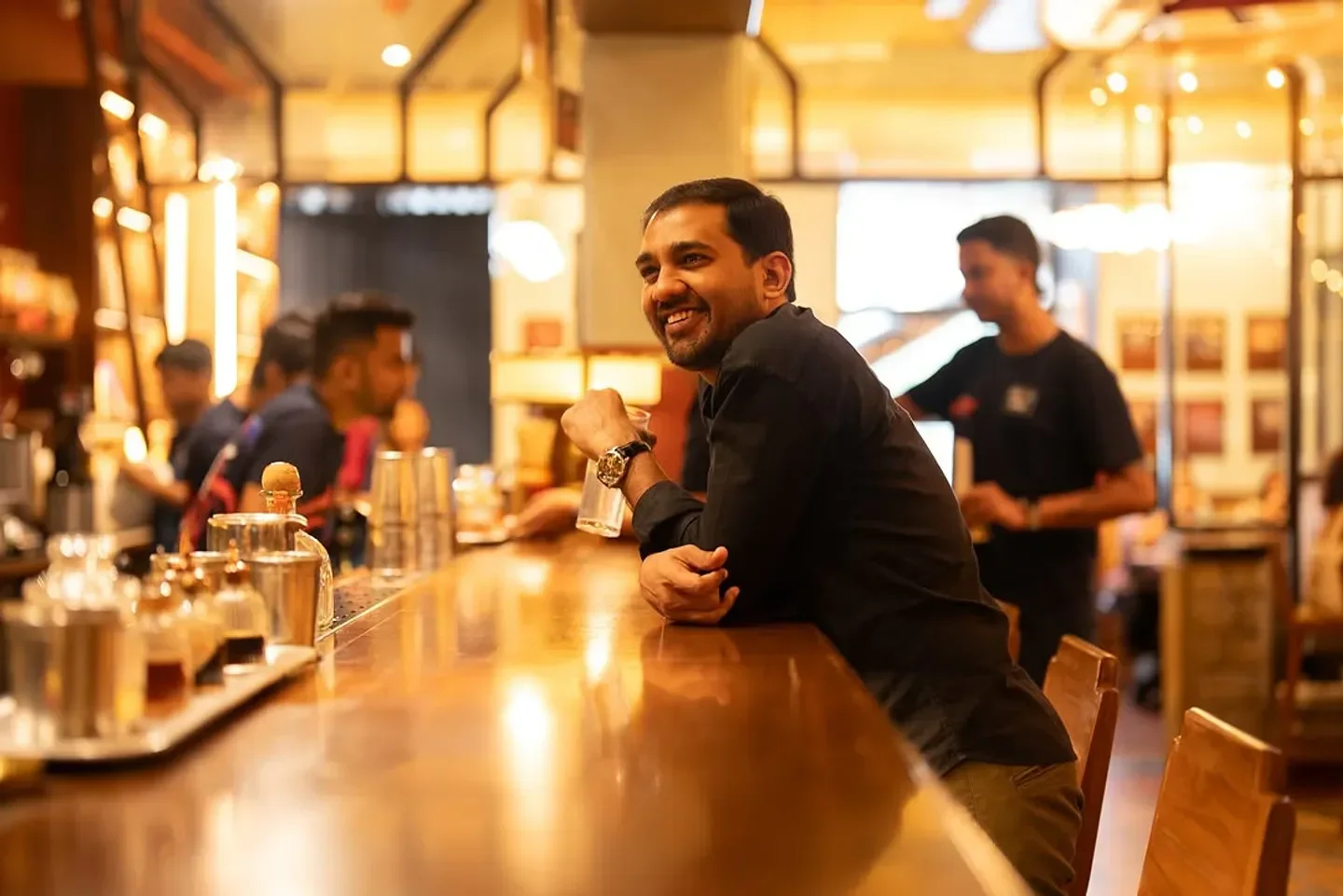 Smiling customer at The Bombay Canteen restaurant in Mumbai, India enjoying a drink.