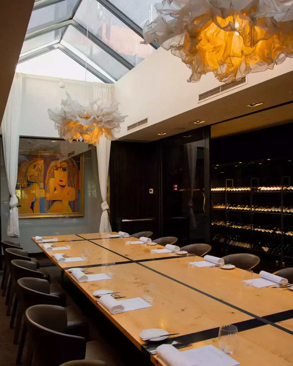 Elegant dining room at The Botanical Hotel in Melbourne, featuring unique light fixtures and artwork.