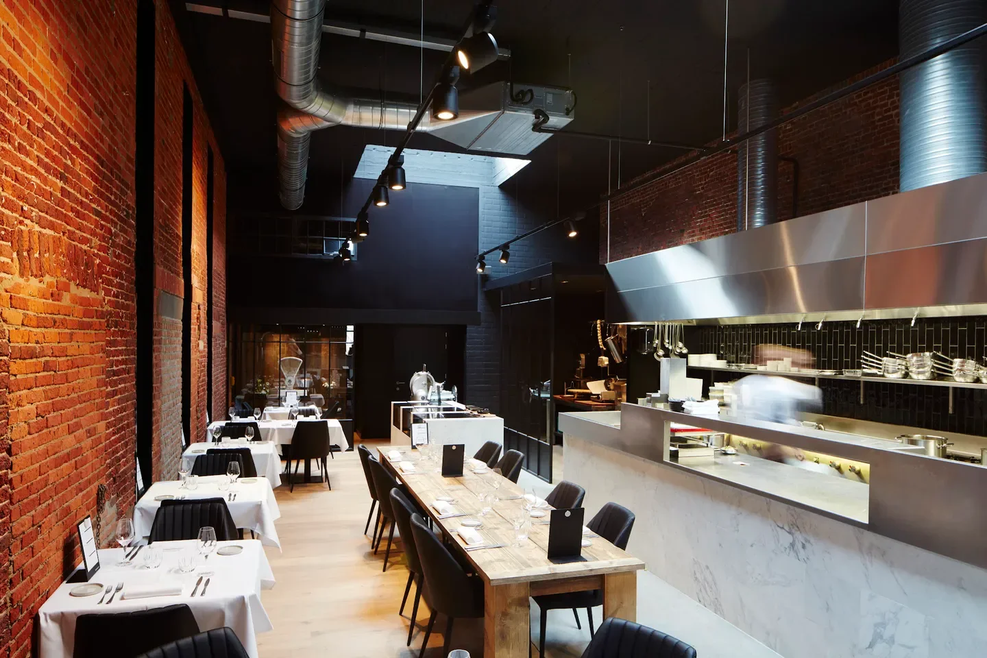Interior of The Butcher's son restaurant in Antwerp, showcasing dining and kitchen areas.