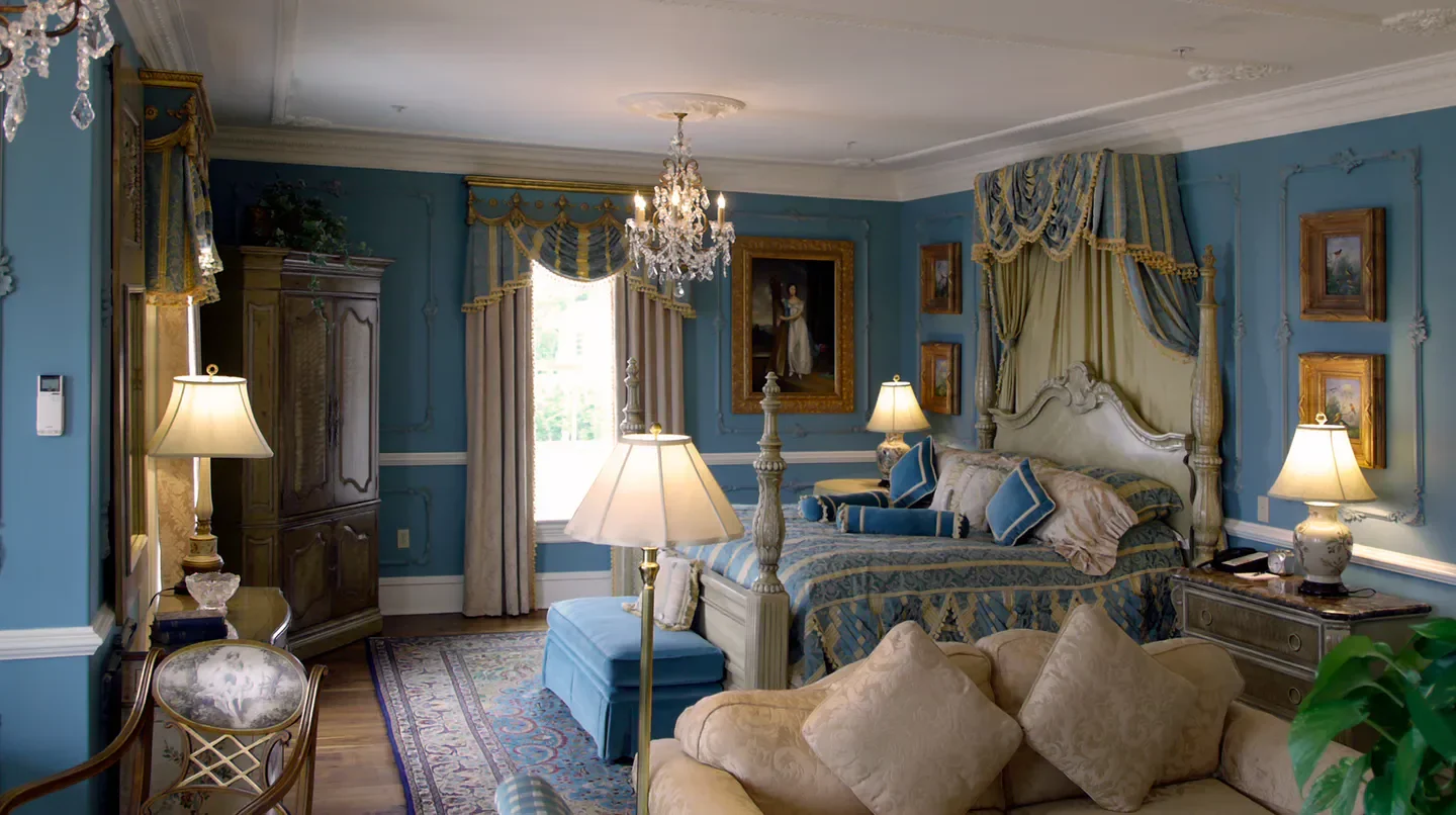 Elegant bedroom at The Chanler at Cliff Walk in Nantucket, featuring classic decor and chandelier.