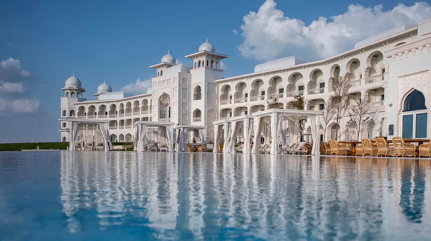 The Chedi Katara Hotel & Resort in Doha, a serene pool reflecting the elegant architecture.