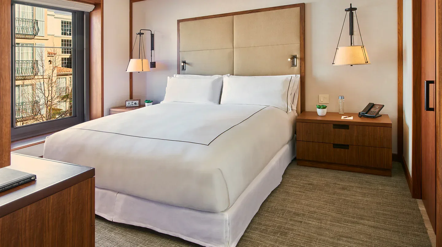 Cozy bedroom at The Clement Hotel in Saratoga, featuring a comfortable bed and city views.
