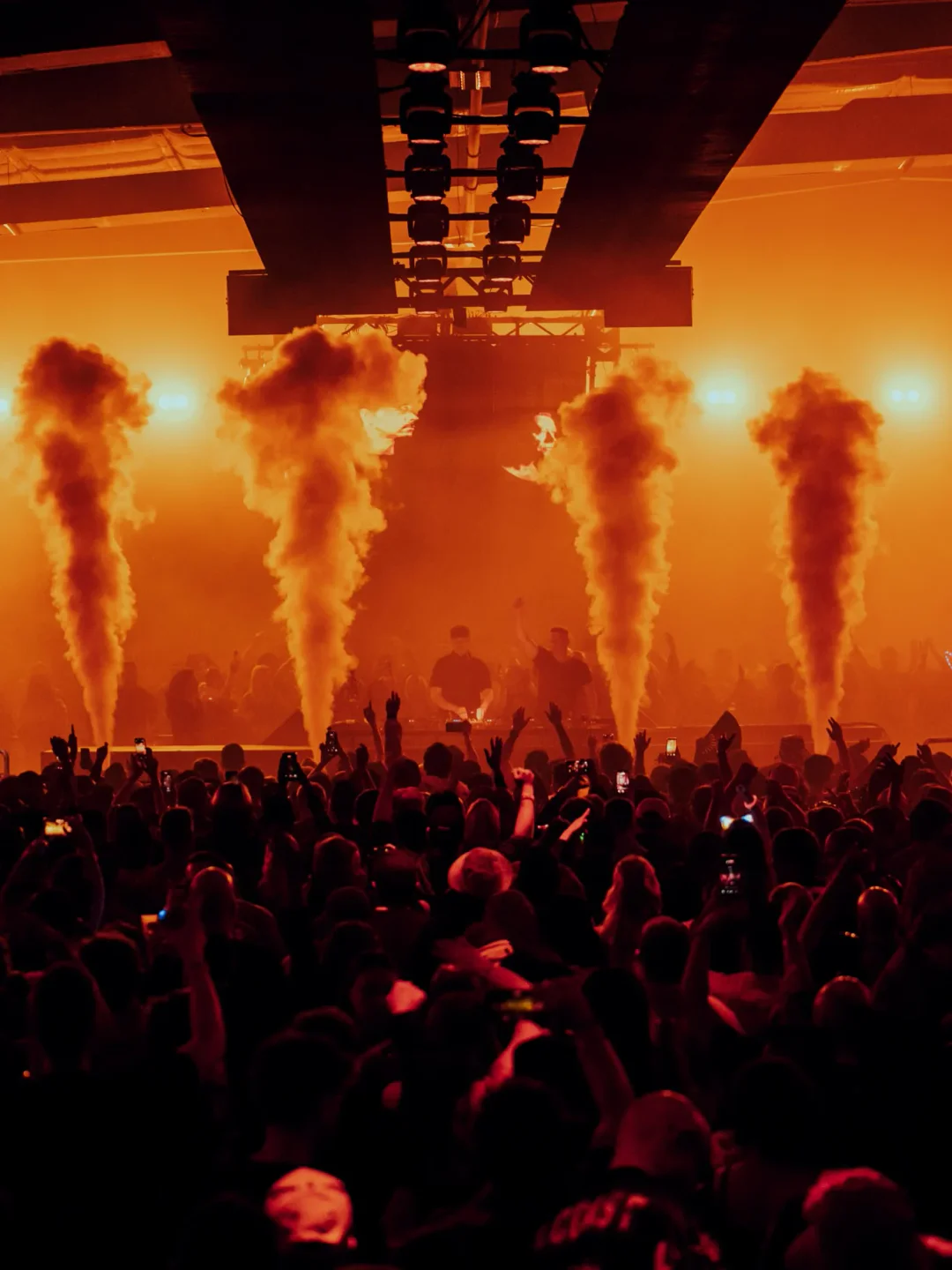 Energetic crowd at The Concourse Project in Austin, enjoying a live music performance with stage lights and smoke effects.
