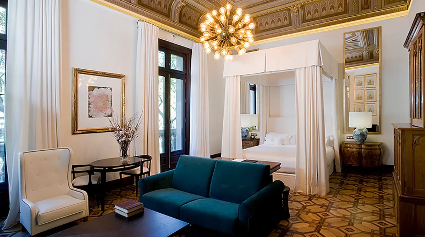 Elegant hotel suite at The Cotton House Hotel in Barcelona, featuring a four-poster bed.