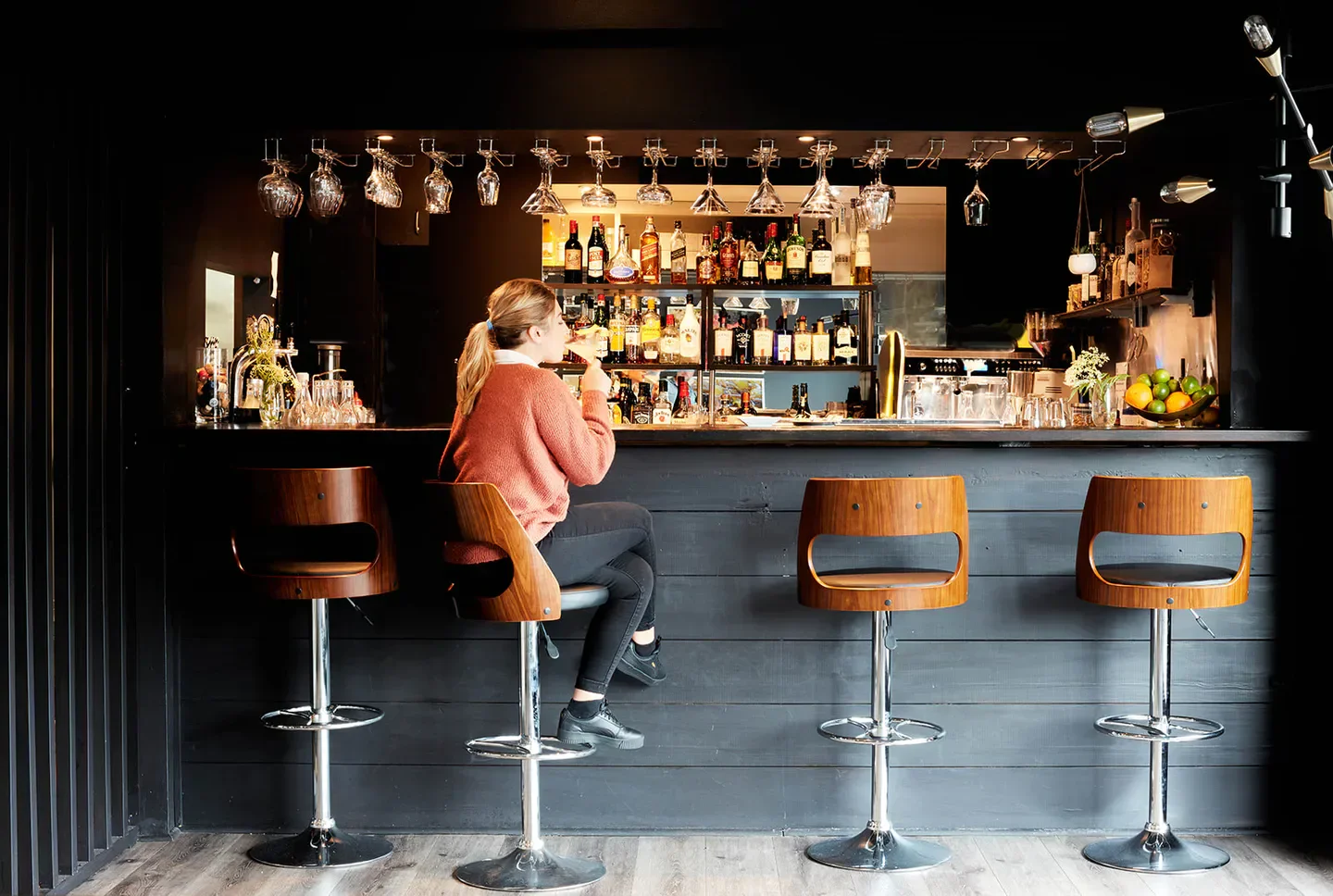 Stylish bar at The Cowrie Restaurant in Central Coast with patron enjoying a drink.