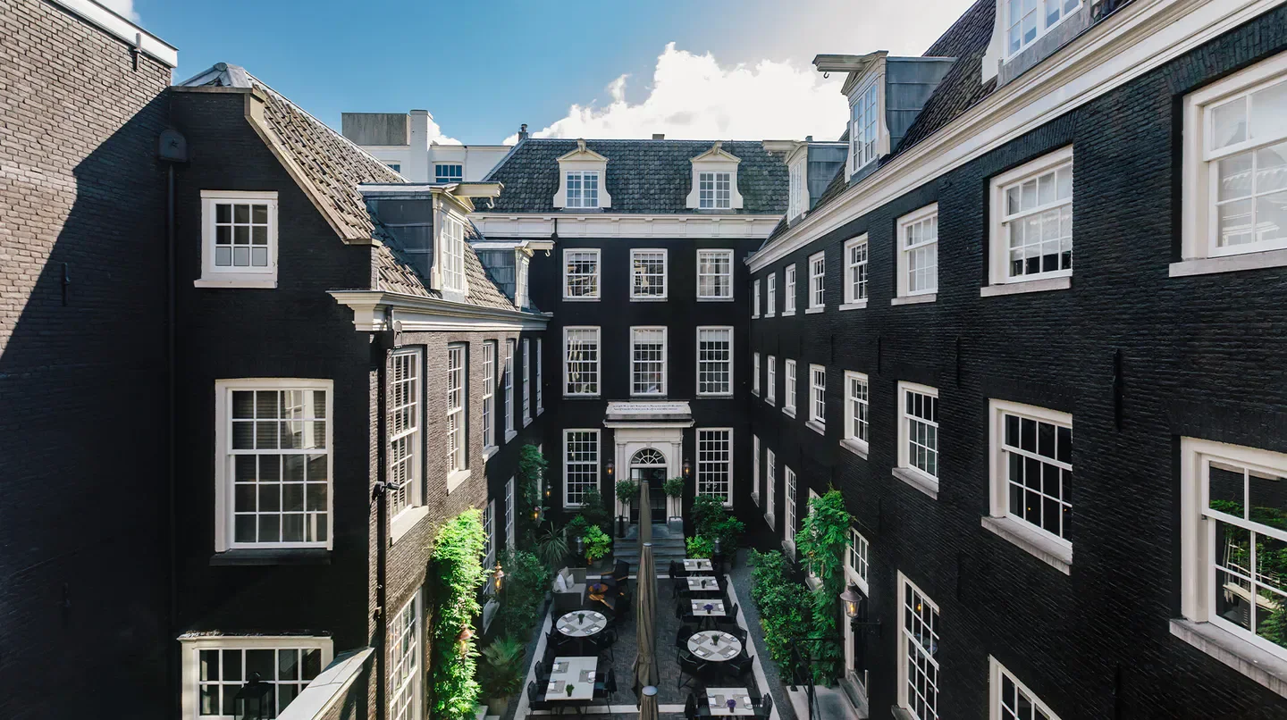 Courtyard view of The Dylan Amsterdam hotel in Amsterdam, showing outdoor seating area