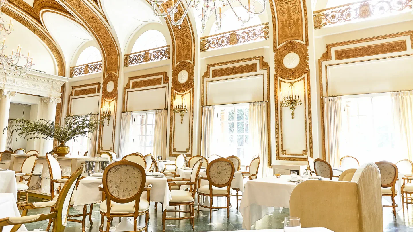 Elegant dining room at The French Room in Dallas, with ornate gold detailing and tables set.