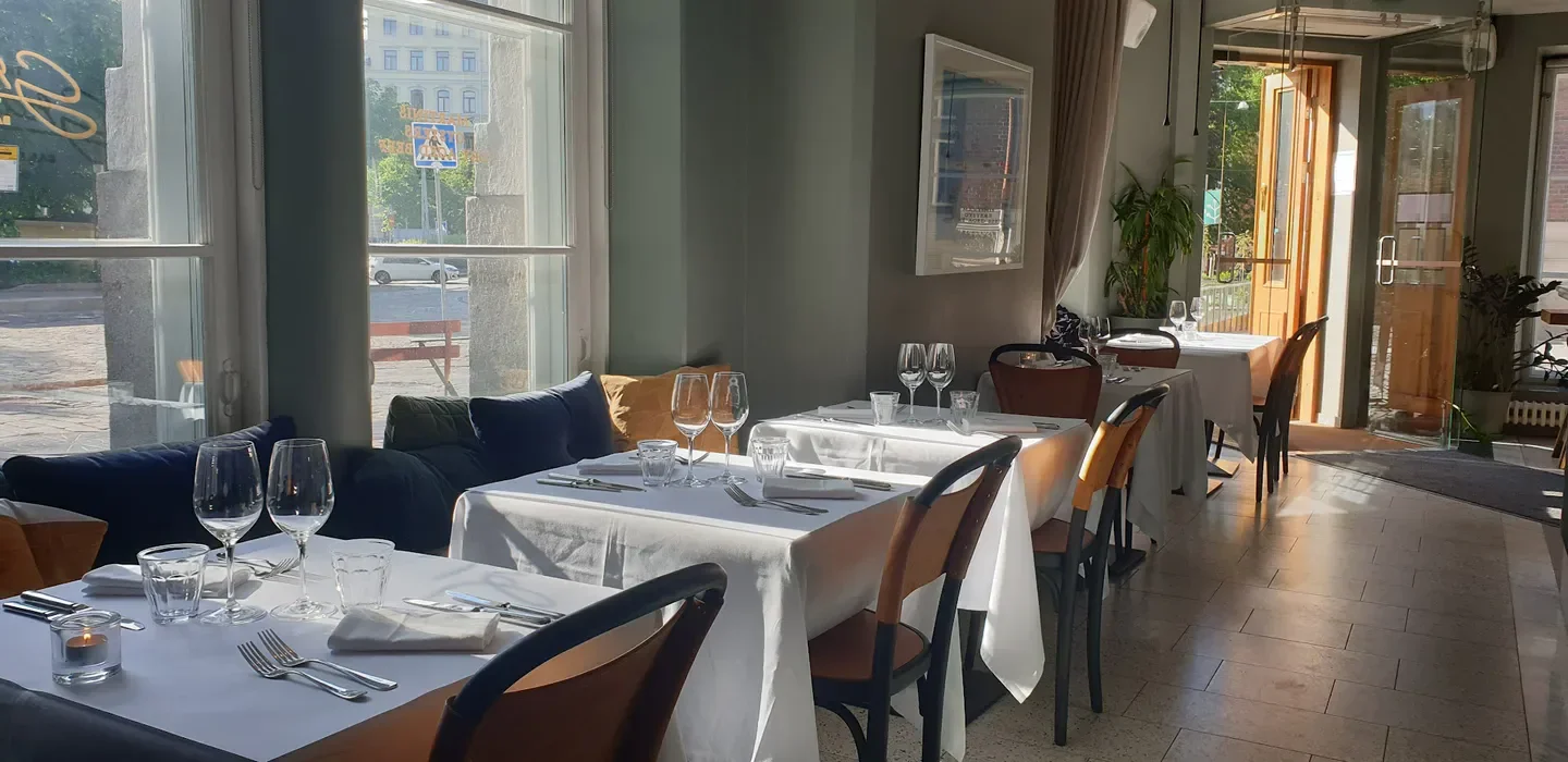 Elegant dining at The Grand Bar & Grill in Helsinki, with sunlight illuminating the tables.