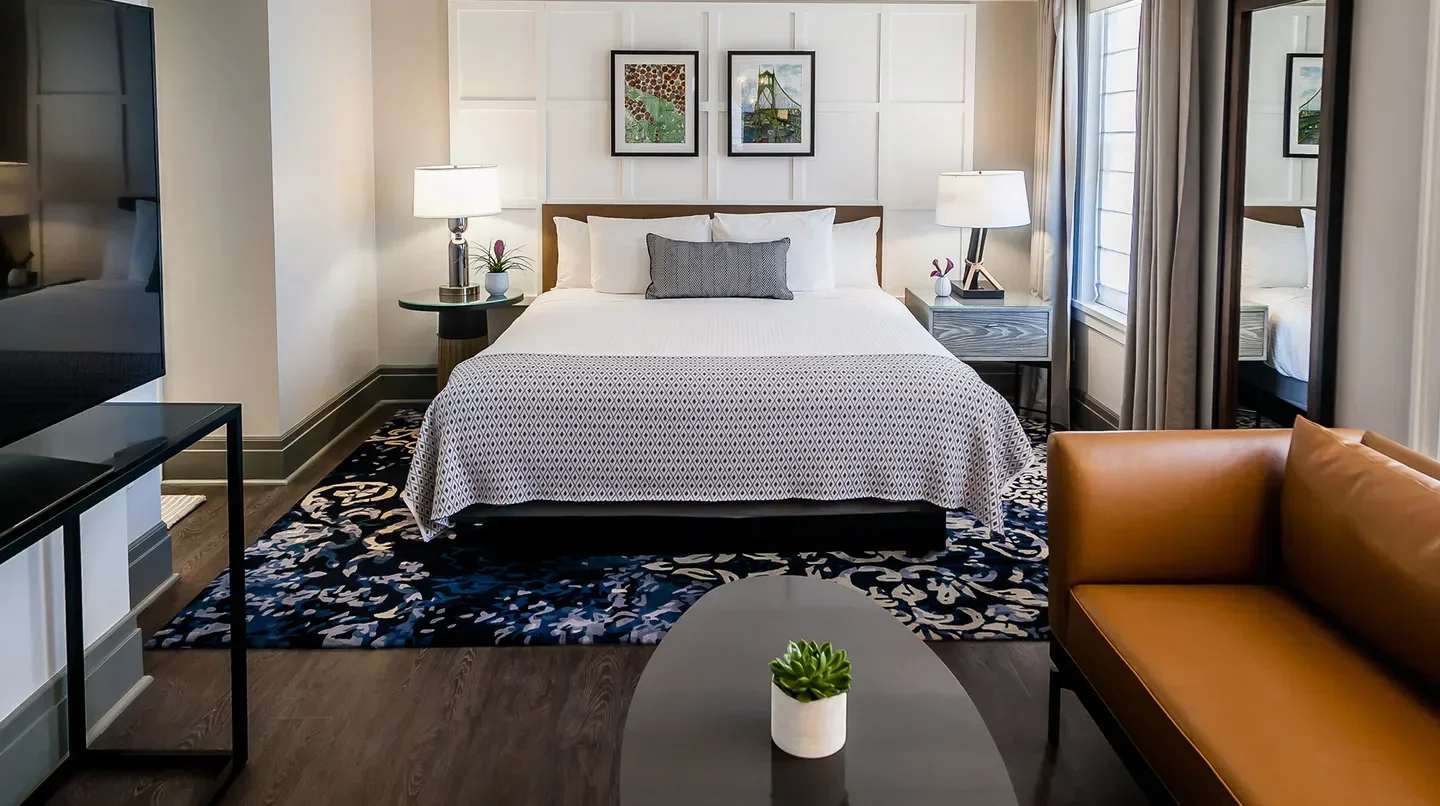 Cozy bedroom at The Heathman Hotel in Portland, featuring stylish decor and luxurious comfort.