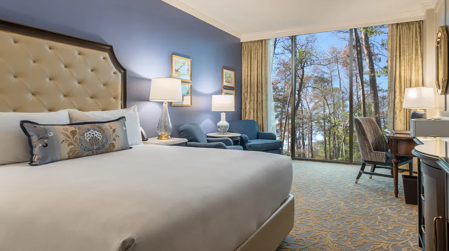 Cozy bedroom at The Houstonian Hotel, Club & Spa in Houston, with forest views.