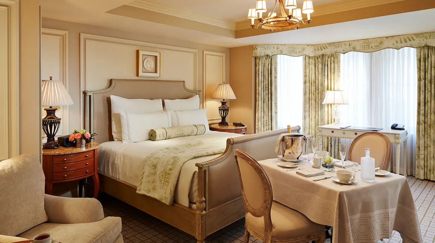 Elegant bedroom at The Jefferson, Washington, DC hotel with dining table and views in Washington.