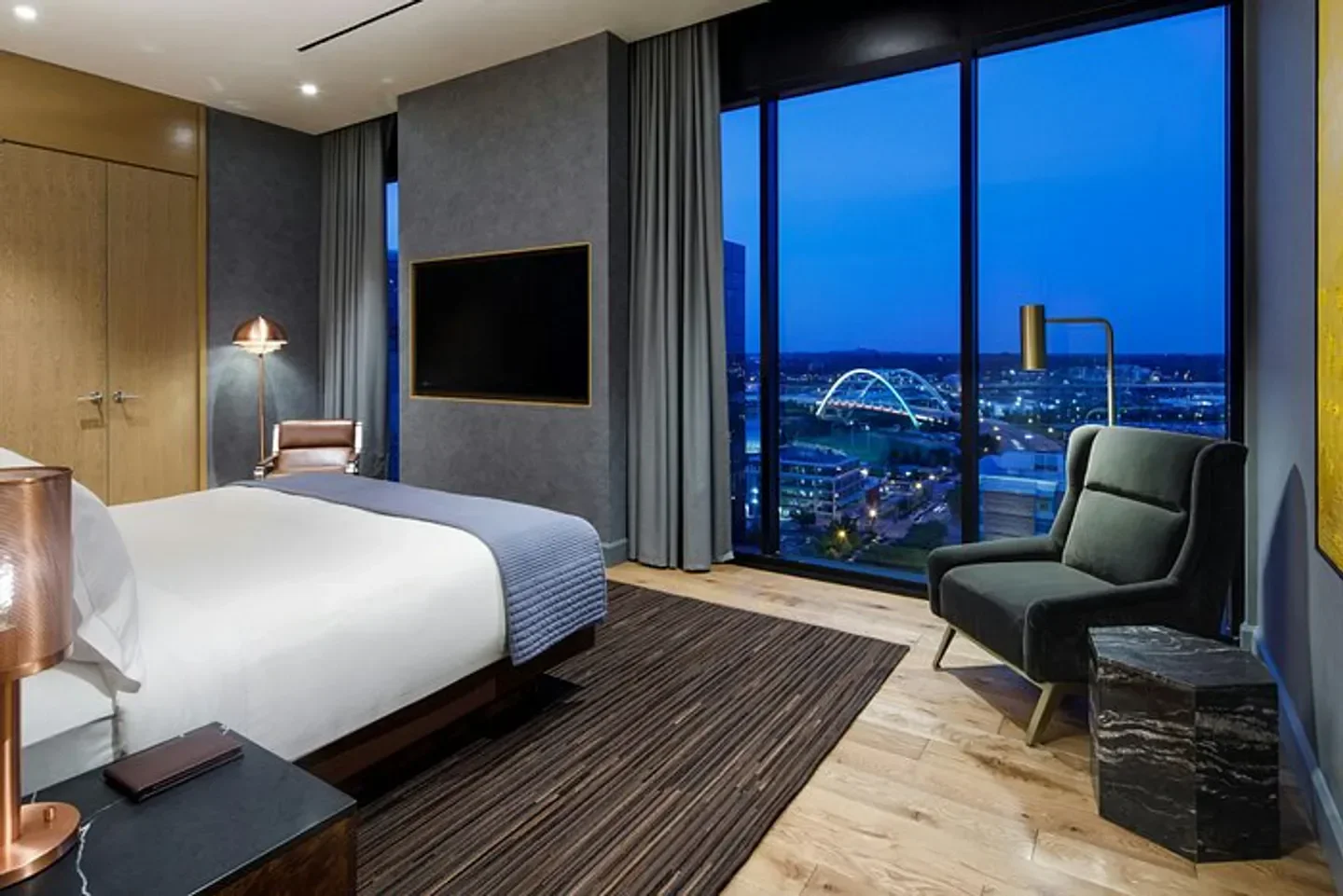 Bedroom view from The Joseph, A Luxury Collection Hotel, Nashville, overlooking Nashville cityscape at dusk.