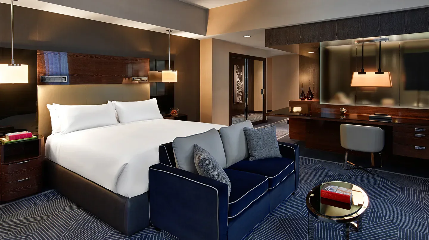 Cozy hotel room at The Joule in Dallas, featuring a comfortable bed and seating area.