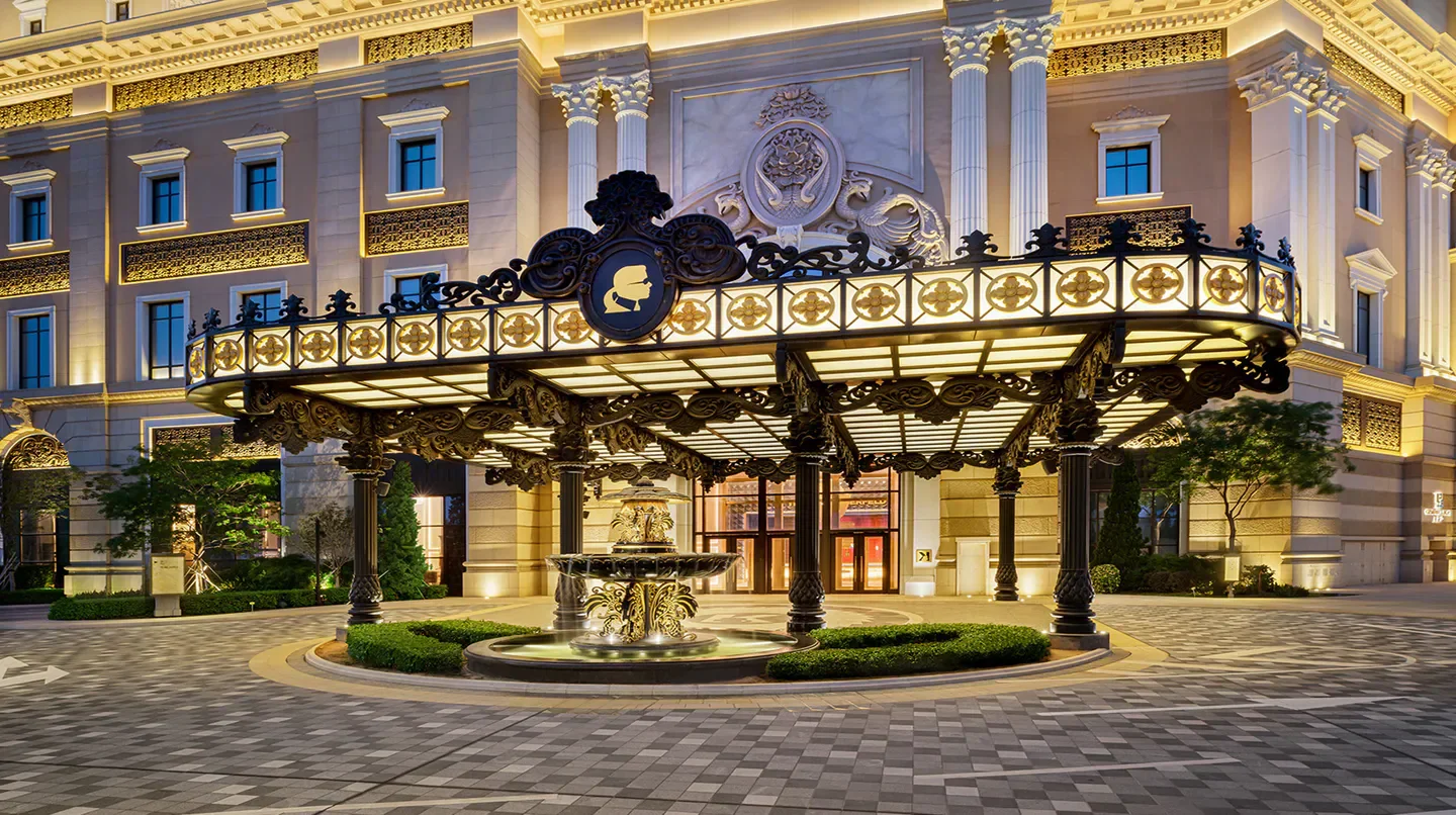 Entrance of THE KARL LAGERFELD hotel in Macau, featuring elegant architecture and a fountain.