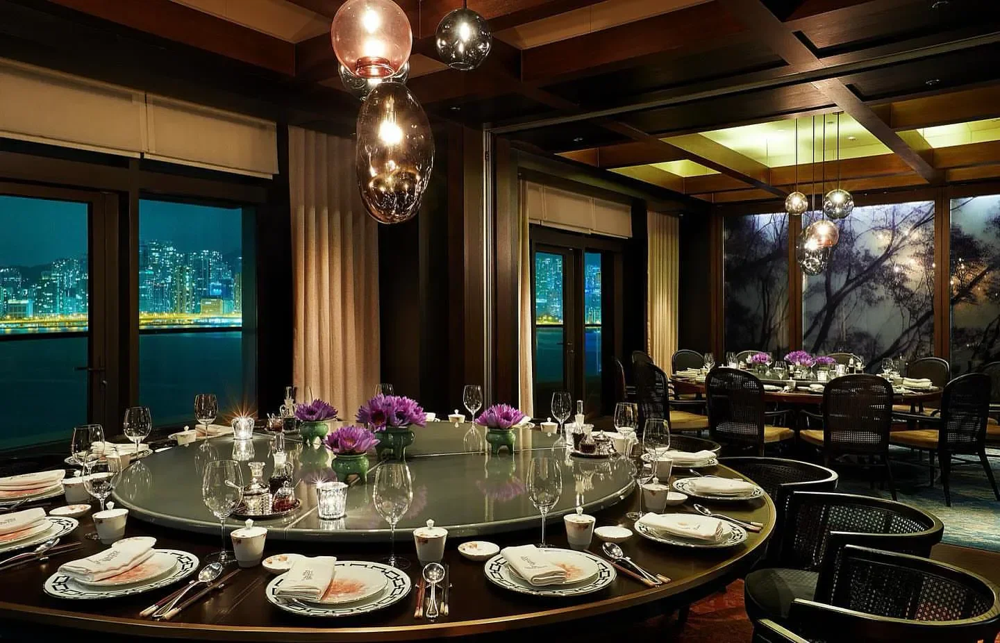 Elegant dining room at The Legacy House in Hong Kong with city views at night.