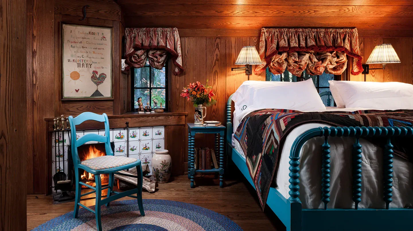 Cozy bedroom at The Lodge at Glendorn, Pittsburgh, featuring a fireplace and colorful decor.