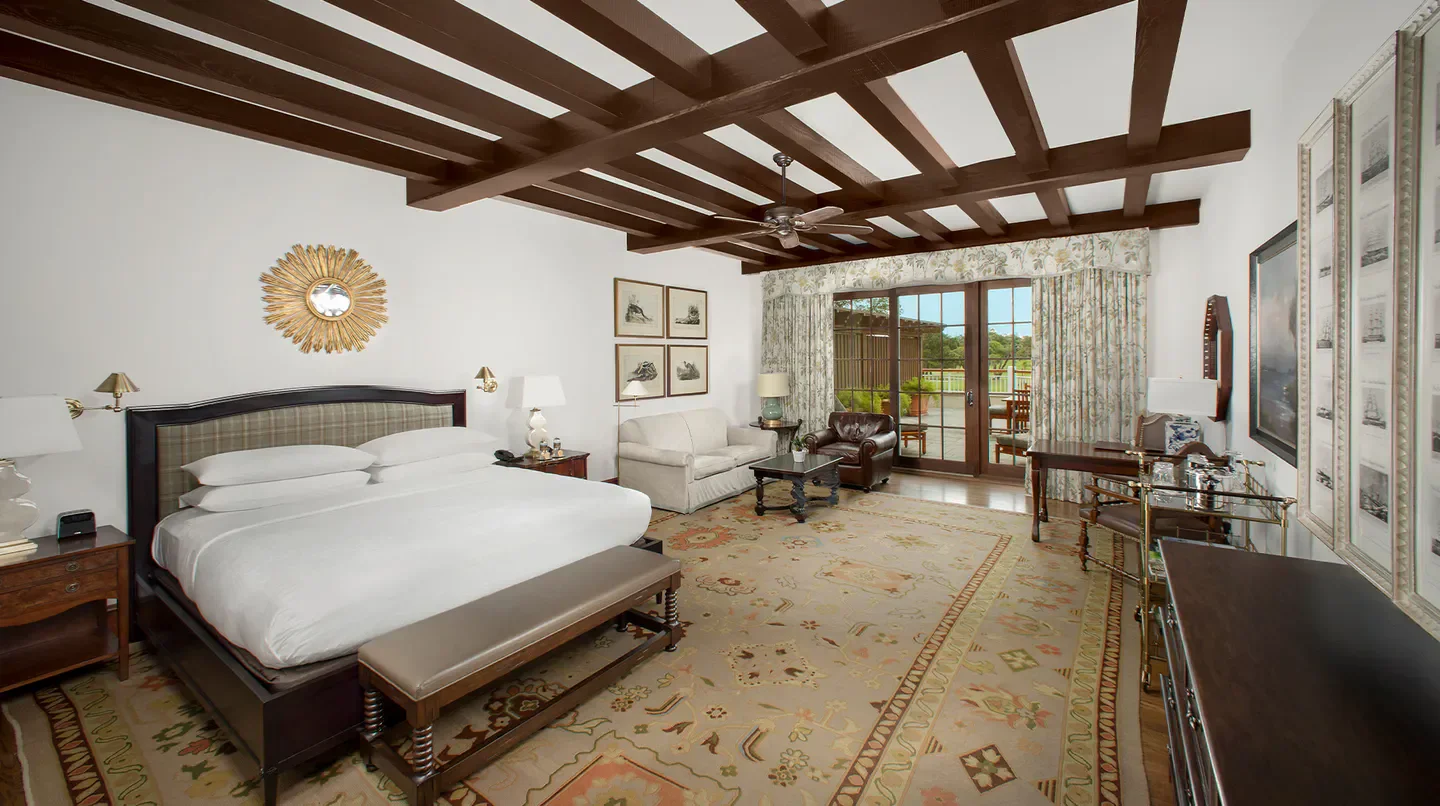Spacious bedroom at The Lodge at Sea Island, Hilton Head Island, with elegant decor and patio access.