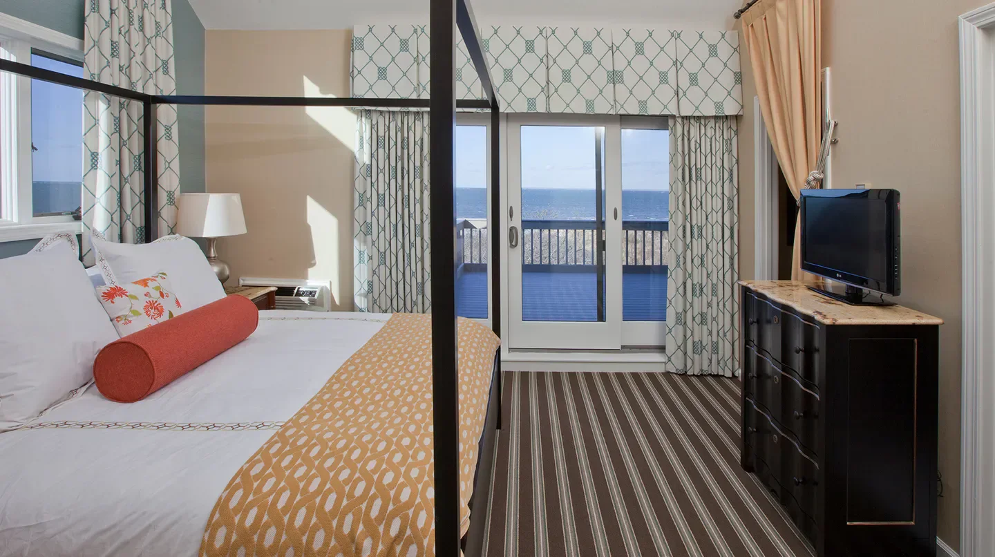 Cozy bedroom at The Mansion at Ocean Edge in Nantucket with ocean view and balcony.