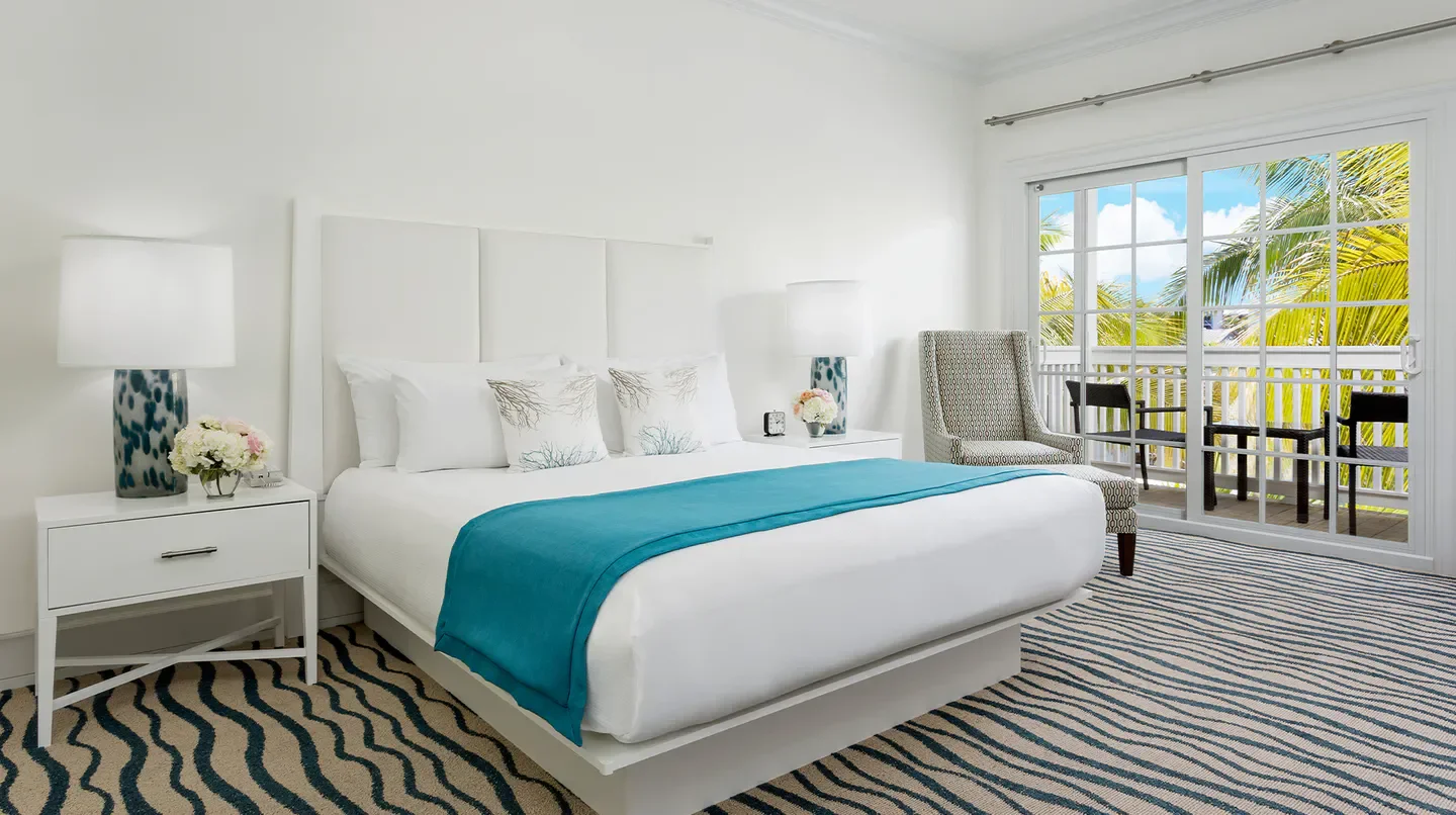 Cozy bedroom at The Marker Waterfront Resort in Orlando, with balcony view.