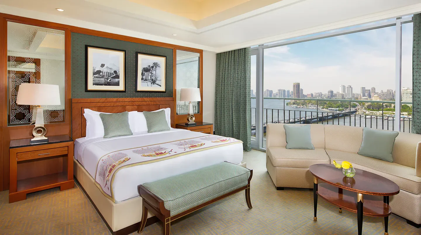 Bedroom with Nile view at The Nile Ritz-Carlton, Cairo, overlooking the city.