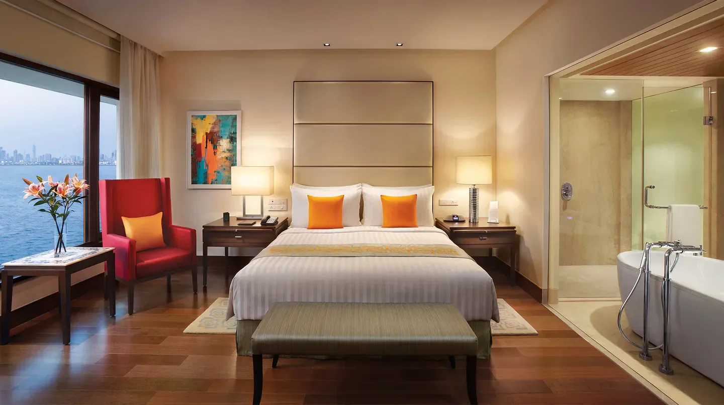 Luxury bedroom at The Oberoi, Mumbai, with stunning views of Mumbai's waterfront.