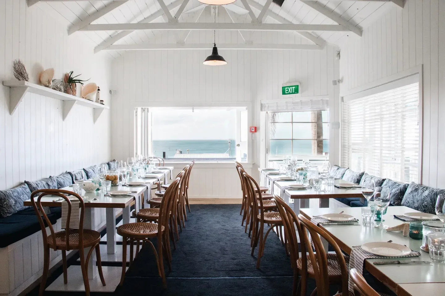 Interior dining at The Oyster Inn restaurant in Auckland, with a view of the ocean