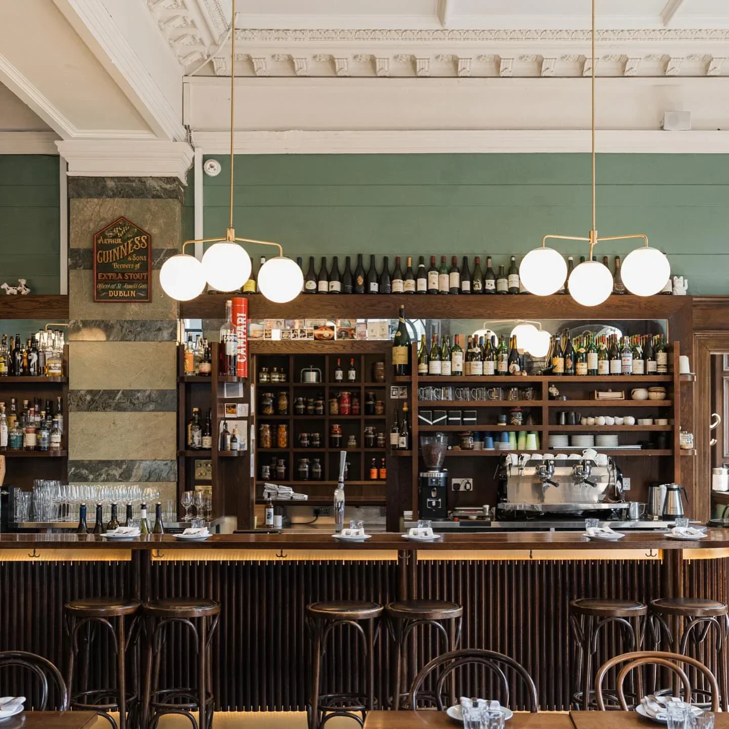 Interior of The Palmerston restaurant in Edinburgh with bar, stools, and hanging lights