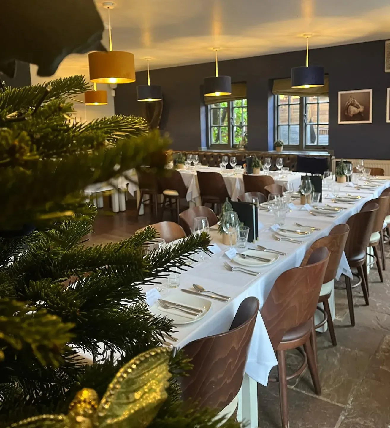 Dining room at The Plough restaurant in Cambridge, set for a meal with festive decor