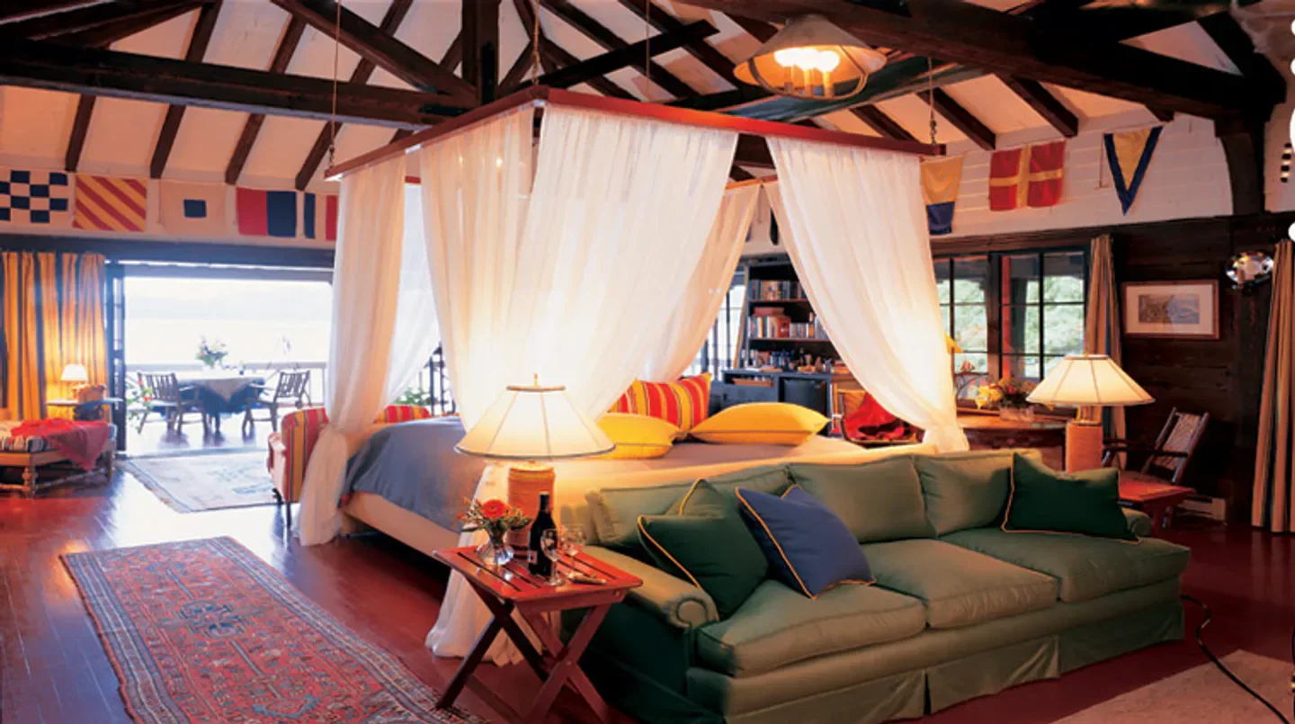 Cozy bedroom at The Point hotel in Saratoga, featuring a four-poster bed and sofa
