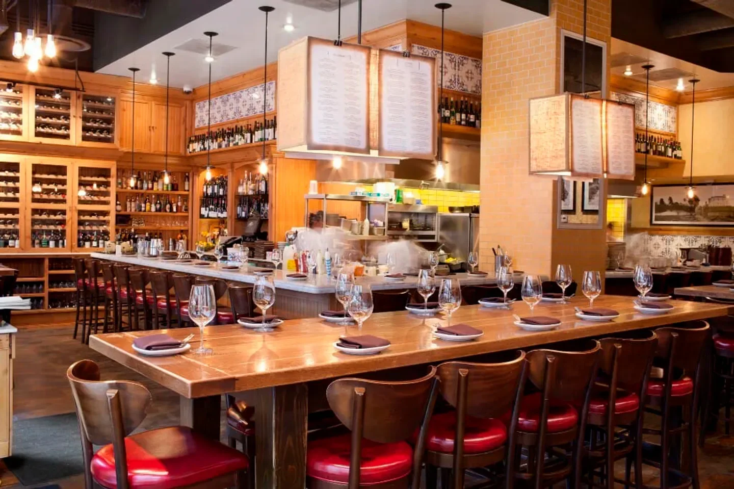 Interior dining at The Purple Pig restaurant in Chicago, with wine glasses and long table