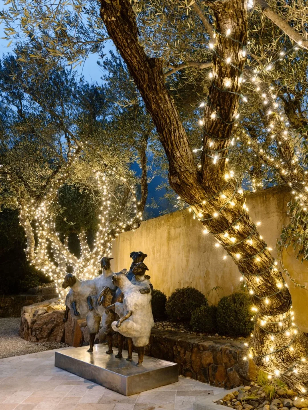 Evening ambiance at The Restaurant at Auberge du Soleil in Napa Valley with sculptures and twinkling lights in trees.
