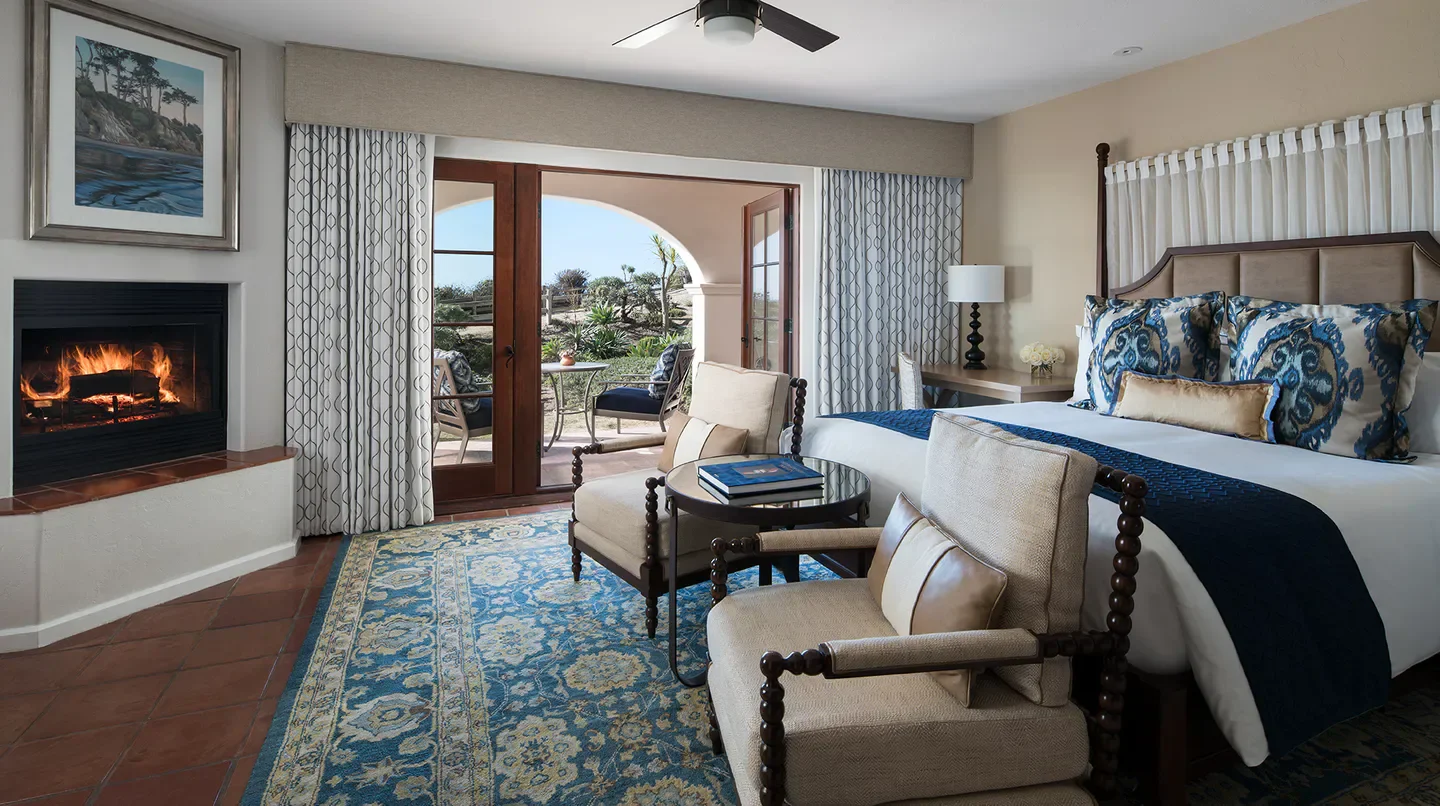 Cozy bedroom at The Ritz-Carlton Bacara, Santa Barbara with fireplace and patio view