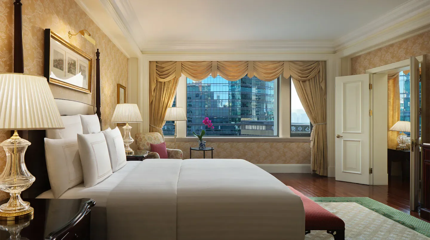 Luxury bedroom at The Ritz-Carlton, Beijing, with views of Beijing's skyline through the window.