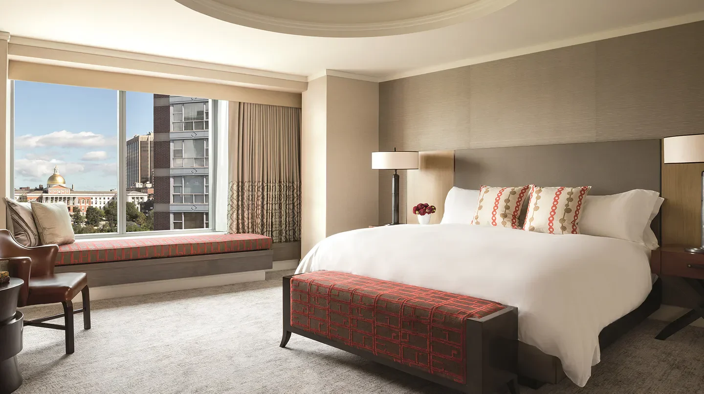 Luxury bedroom at The Ritz-Carlton, Boston, with city views of Boston through large windows