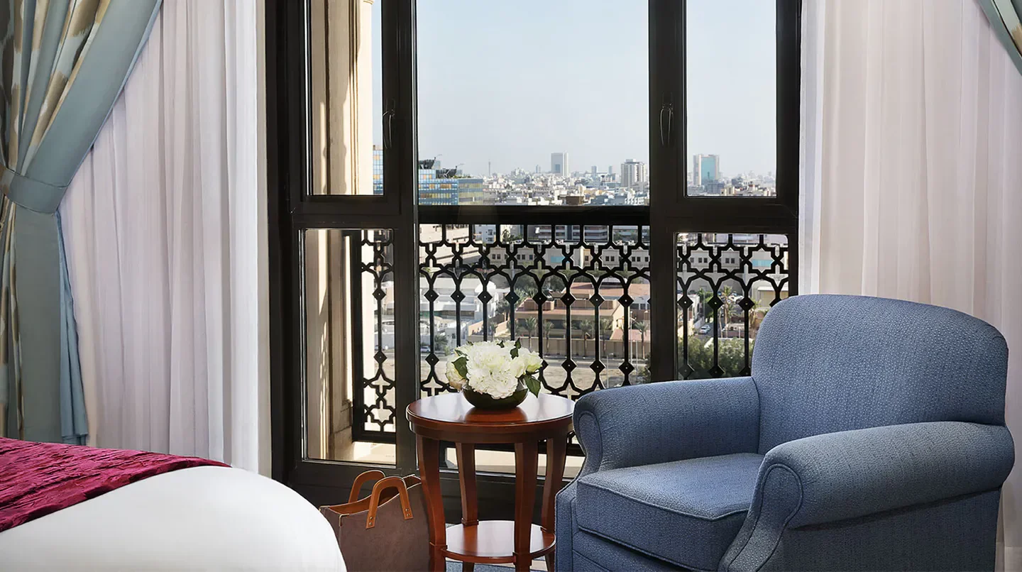 Cozy room with city views at The Ritz-Carlton, Jeddah, featuring elegant decor.