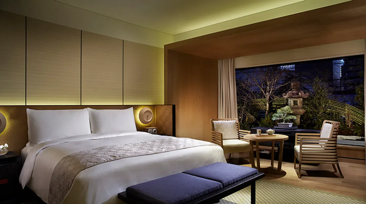 Cozy bedroom at The Ritz-Carlton, Kyoto, with a view of a traditional garden in Kyoto.