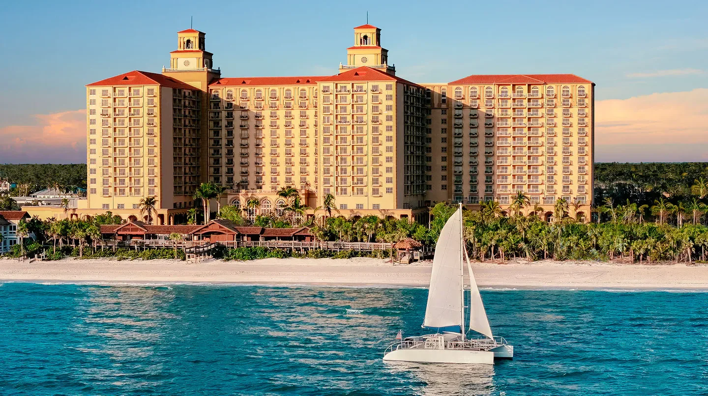 The Ritz-Carlton, Naples hotel overlooking the ocean in Naples Florida with a sailboat.