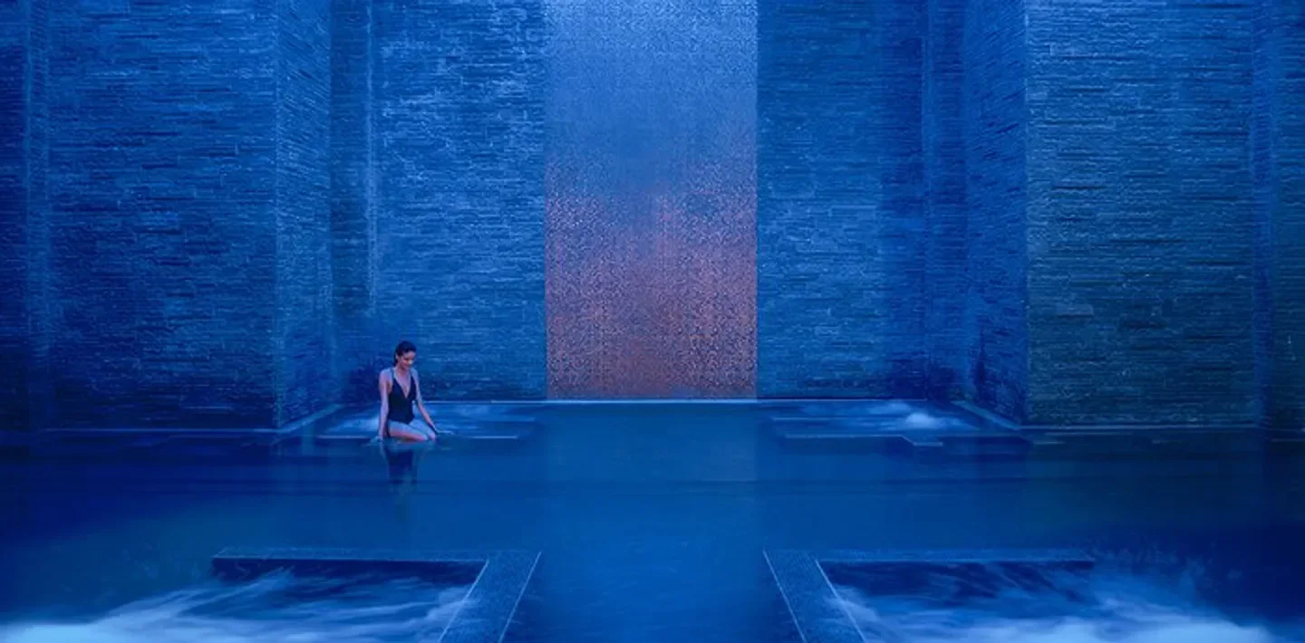 Woman relaxes in pool at The Ritz-Carlton Spa, Al Wadi Desert, Dubai's luxurious spa.