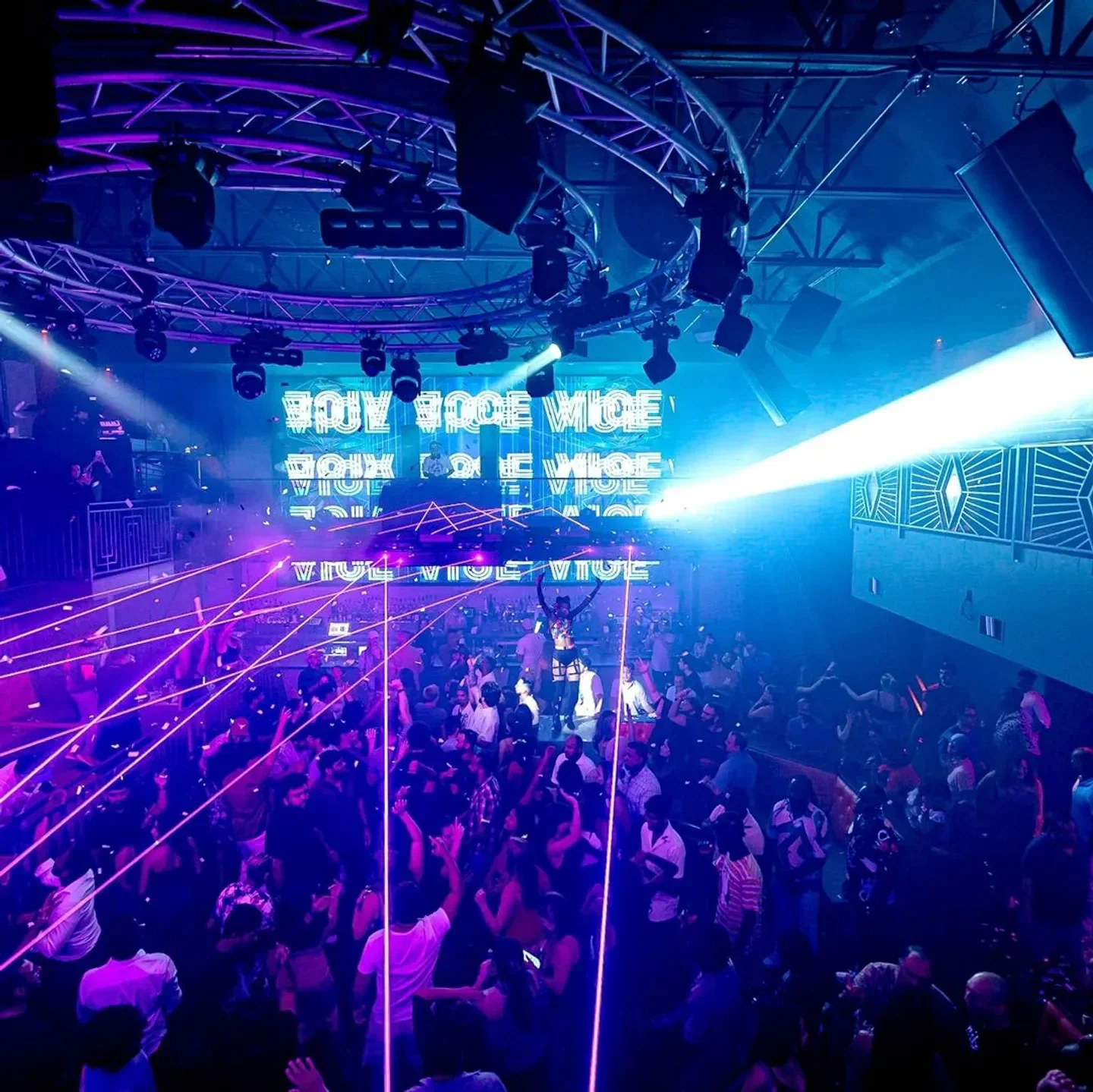 Energetic crowd at The Rose Room nightclub in Austin, with neon lights and laser beams.
