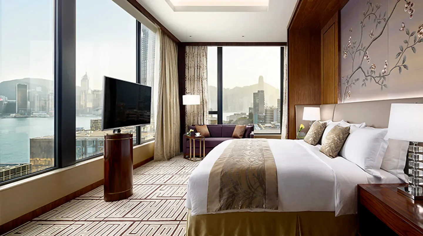 Luxury hotel room with views of Hong Kong at The Royal Garden, featuring city skyline.