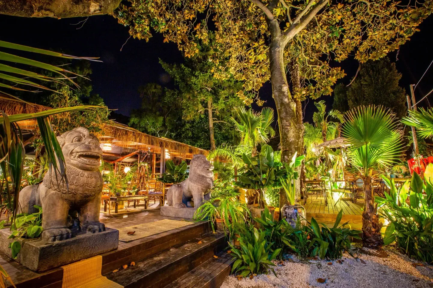 The Sanctuary in Rome: Nighttime view of a lush outdoor restaurant with stone statues.