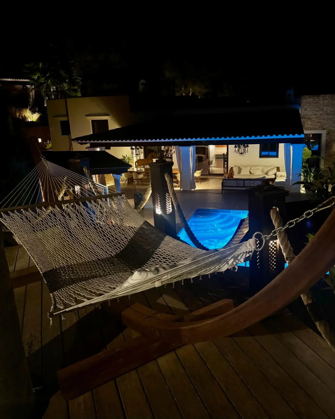 The Social Haus restaurant in the-bahamas at night featuring a hammock and glowing pool.