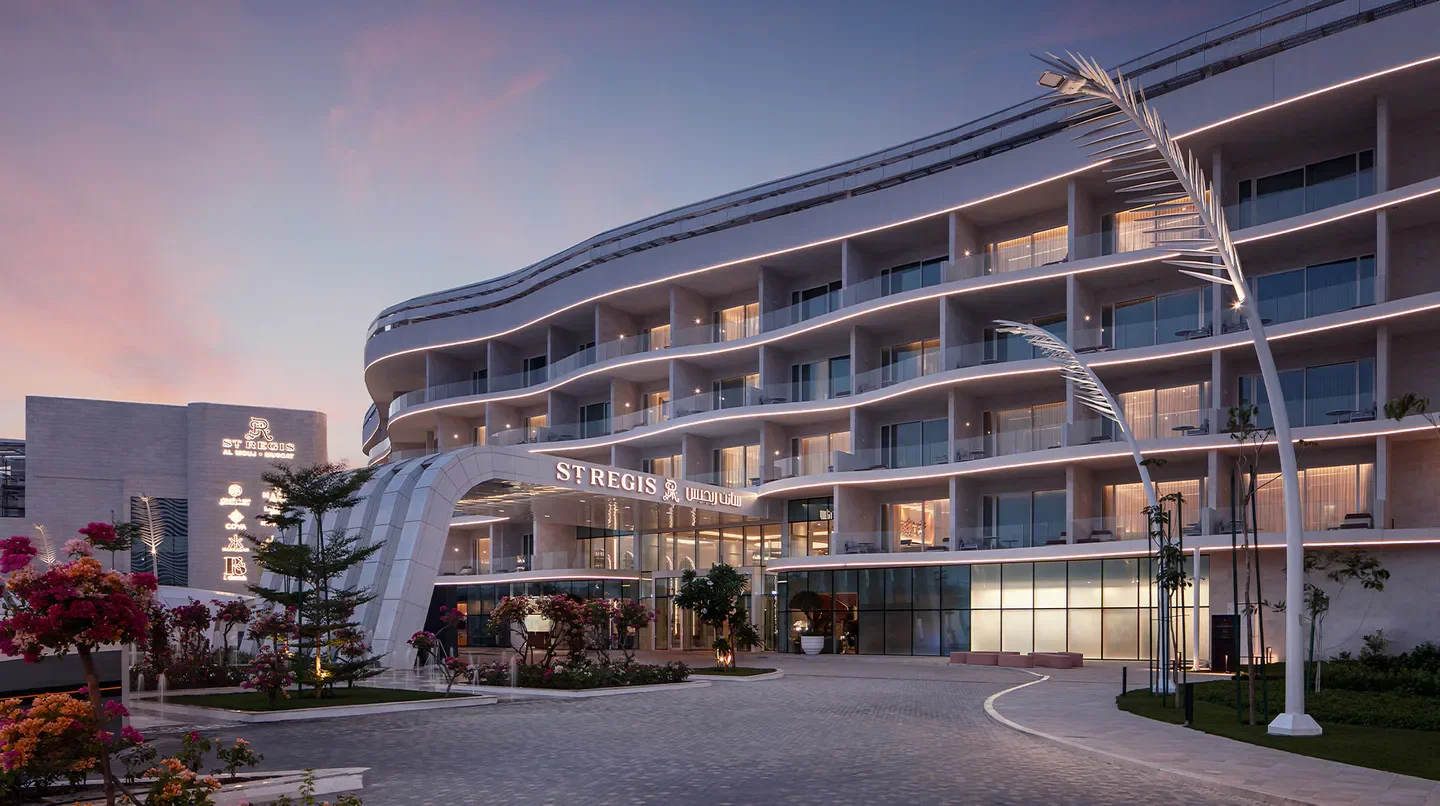 Exterior of The St. Regis Al Mouj Muscat Resort at dusk in Muscat, Oman.