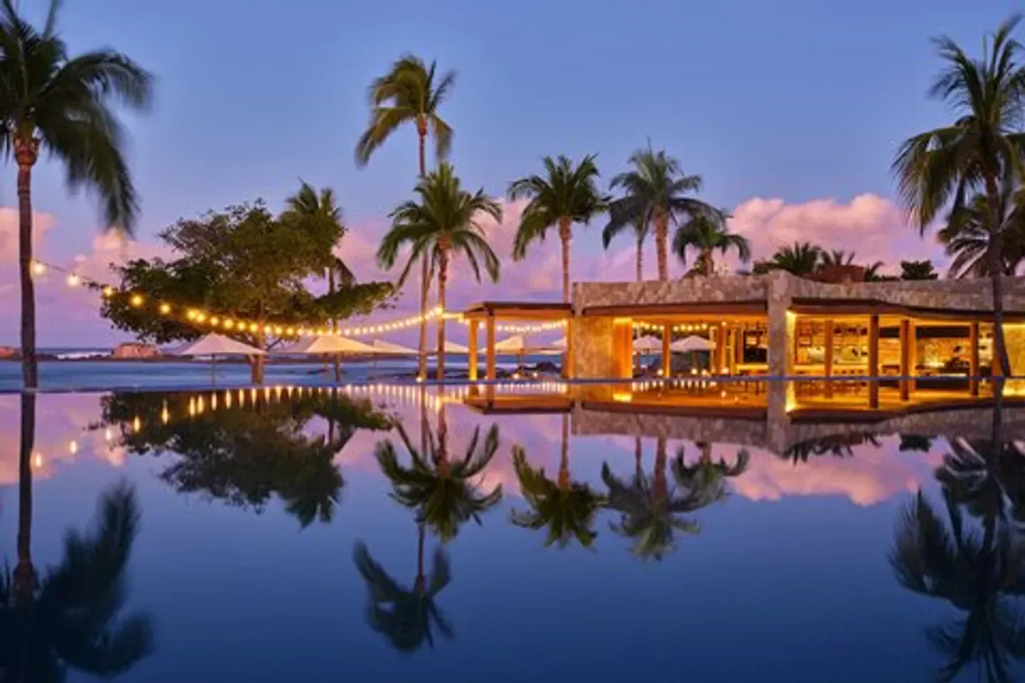 Evening view of The St. Regis Spa at Punta Mita, Puerto Vallarta, palm trees and reflection.