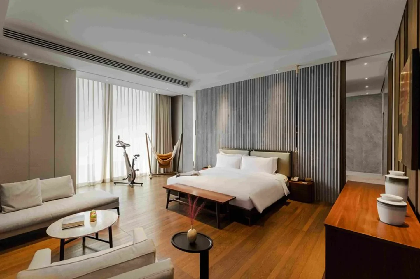 Spacious bedroom at The Sukhothai Shanghai hotel with exercise bike, Shanghai.