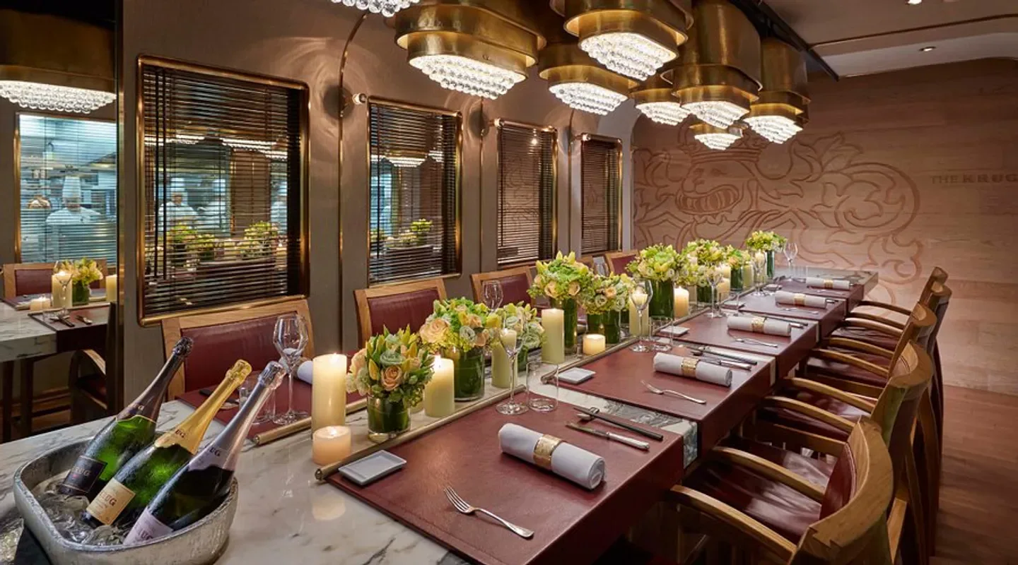 Elegant dining at The Tai Pan restaurant in Hong Kong, with champagne and floral arrangements.
