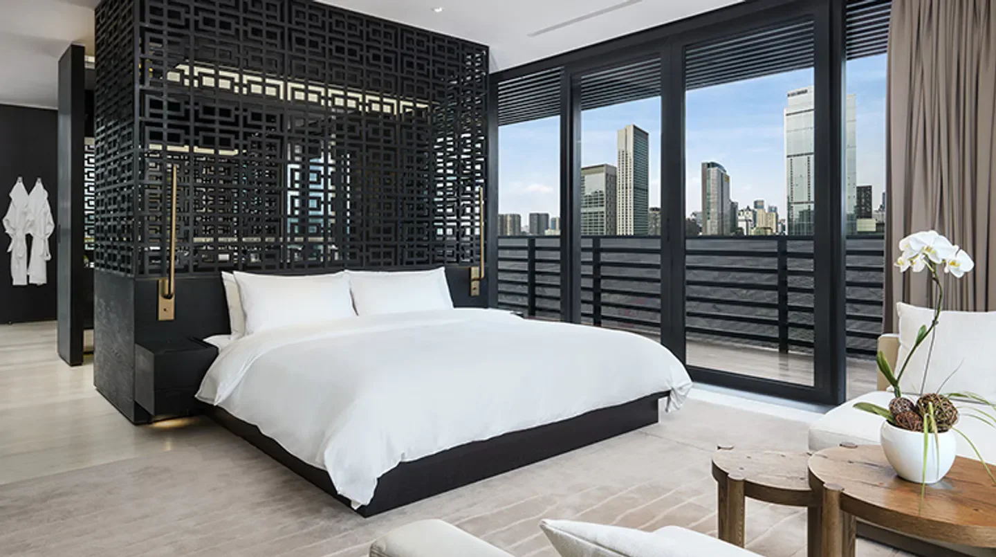 Modern bedroom at The Temple House hotel in Chengdu with city views.