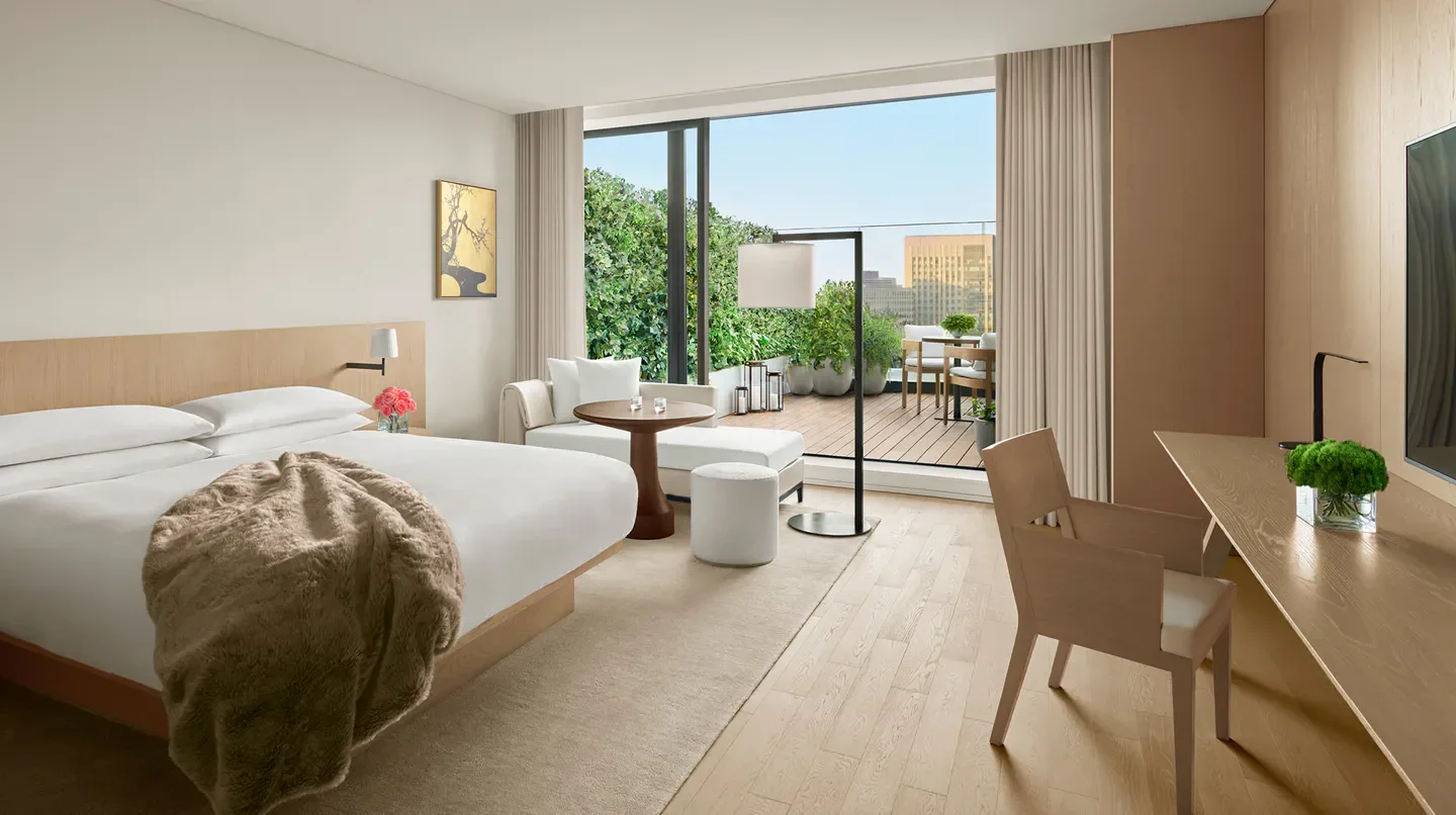 Spacious bedroom at The Tokyo EDITION, Toranomon, with balcony overlooking Tokyo.