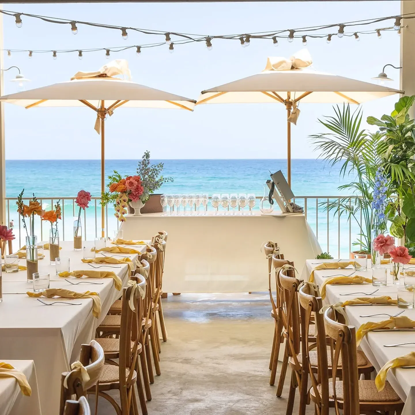 Tables set for dining at The Tropic restaurant, Gold Coast, with ocean views and parasols